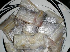 带鱼解冻后去除内脏，剪掉头尾，洗净剪成长段，抹上盐和料酒腌制片刻