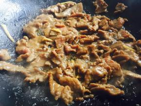 炒锅洗净后烧热，加入适量的花生油，油热后把腌好的牛肉片放入翻炒至变色后出锅