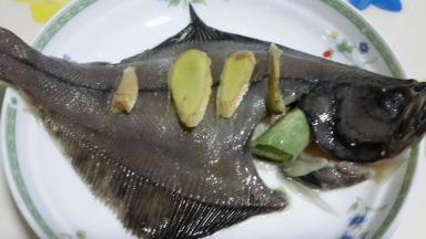 用盐涂抹鱼身，涂抹均匀融入鱼肉中，撒上葱段和姜片，淋上蒸鱼豉油