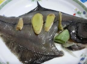用盐涂抹鱼身，涂抹均匀融入鱼肉中，撒上葱段和姜片，淋上蒸鱼豉油
