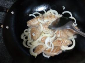 炒锅热油，放入葱蒜炒香，放上鸡翅翻炒，炒至双面金黄后放入洋葱丝，加盐、白糖、酱油和少量清水，小火焖煮