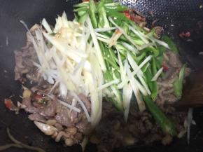 倒入切好的姜丝和辣椒丝，炒至断生