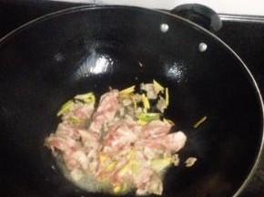 放入羊肉片，倒入料酒，生抽，快速翻炒至变色