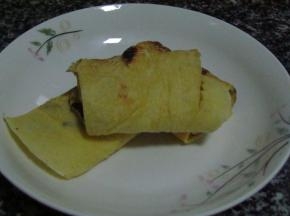 煎成两面金黄出锅，卷成蛋卷，用刀切成段即可