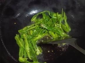 油热后把蒜粒放入爆香，加青椒爆炒