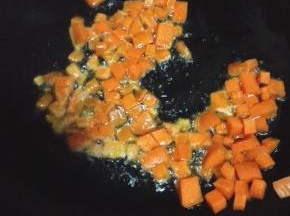 锅内留底油，放入胡萝卜和豌豆翻炒至变软