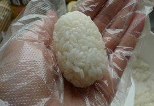 手上蘸取少许清水，用手捏一小团米饭成长方体状，将烤鳗鱼放在米饭上，用海苔条包好即可