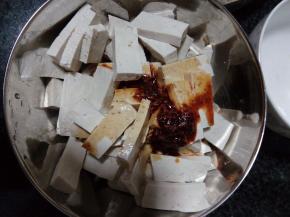 豆腐块加蒜蓉、红油辣椒、盐、酱油、香油调味，拌匀后即可开吃