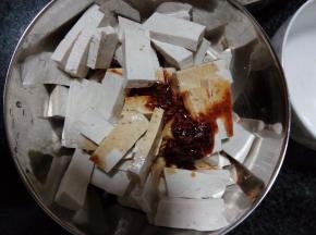 豆腐块加蒜蓉、红油辣椒、盐、酱油、香油调味，拌匀后即可开吃