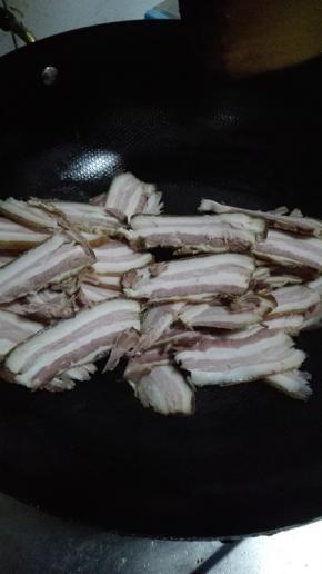 炒锅放少许的油，油热倒入腊肉翻炒至逐渐变透明