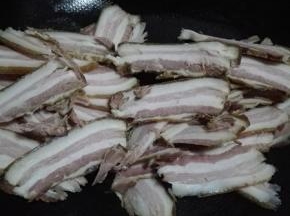 炒锅放少许的油，油热倒入腊肉翻炒至逐渐变透明