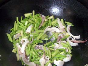 放入鱿鱼煸炒均匀，加料酒去腥，放入适量白糖和鸡精增鲜，炒匀后出锅