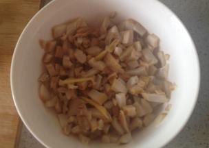 用刷子把鲍鱼刷干净，把鲍鱼肉切成小粒粒，放入碗里，再加入几滴料酒，少许葱姜，腌制片刻去腥