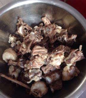 羊蝎子冷水下锅，放入花椒和料酒，沸腾之后煮5分钟。撇去血沫，捞出羊蝎子沥干水分备用