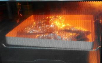从冰箱中取出腌制好的鸡腿，放入锡纸中包好，放入烤盘