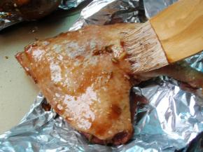 打开锡纸，在鸭腿表面刷上腌料和蜂蜜汁