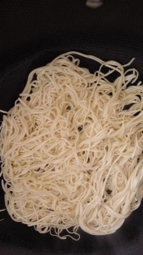 平底锅放少许的油，油热之后放入挂面，摆成圆形