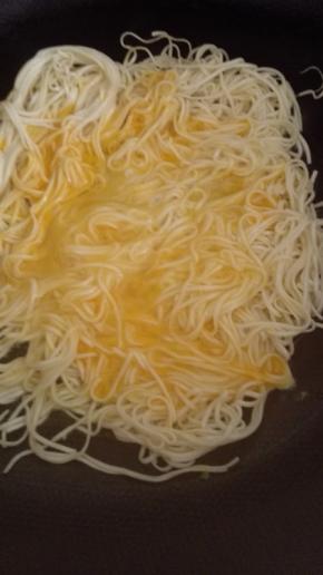 鸡蛋打入碗中搅拌均匀，倒入挂面上，小火煎至底部金黄定型