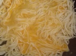 鸡蛋打入碗中搅拌均匀，倒入挂面上，小火煎至底部金黄定型
