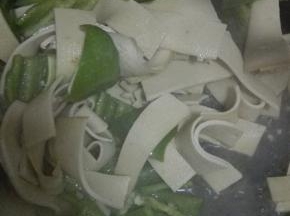 锅中的汤汁快干的时候放入青椒，盐和鸡精，翻炒至断生