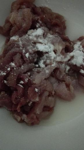 切好的猪肉倒入料酒，盐和水淀粉抓拌均匀