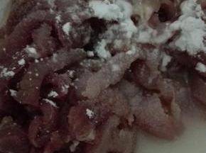 切好的猪肉倒入料酒，盐和水淀粉抓拌均匀