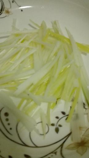 大葱洗净，取葱白的部分切成细丝，摆在盘底