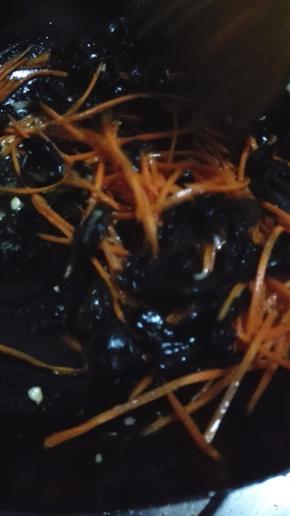 锅内的底油放入蒜末炒香，倒入萝卜丝和黑木耳