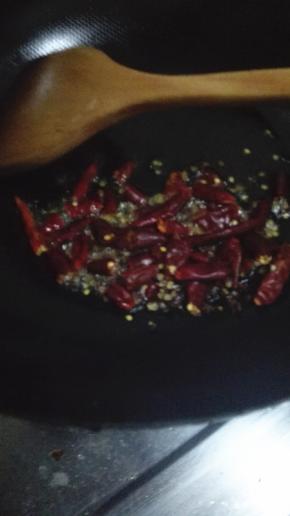 炒锅内加适量的油，油热之后倒入花椒粒和姜片，干辣椒，小火炒出香味