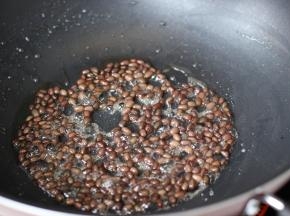 锅中少水，加白糖翻炒糖融放红豆