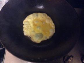 锅中倒入少许菜籽油，将打散的蛋液倒入锅中，均匀的摊开，煎成蛋饼，装盘备用