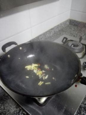 油锅加热，倒入姜丝、蒜片和干辣椒炒香