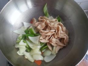 翻炒几下后，放入斜切成块状的肥肠煸炒