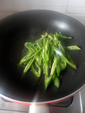 锅中放油，倒入青椒翻炒，8成熟后加入鸡肝片