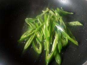 锅中放油，倒入青椒翻炒，8成熟后加入鸡肝片