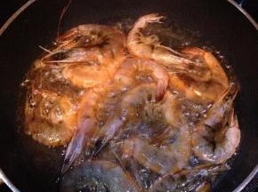 将虾放入油锅中慢火温煎2分钟，出锅沥干油备用