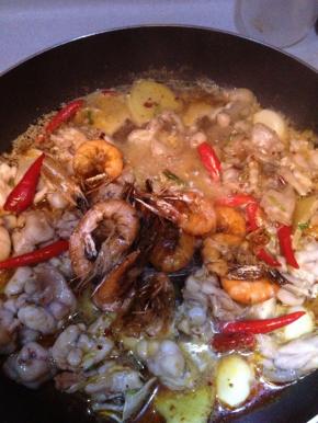 放入小红尖椒，2-3勺辣椒油和花椒油，放入煎好的虾。翻炒，盖上锅盖焖3-5分钟，使其浸入汤汁中充分吸收佐料