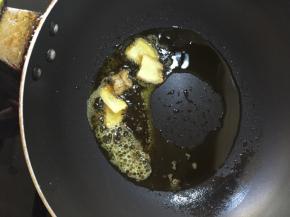 炒锅倒油，锅中油开始冒泡，放入姜片提味