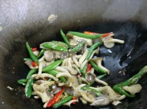 锅内留底油，放入辣椒炒至表皮泛白