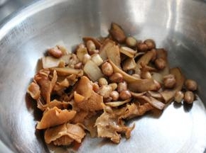 将炸好的树耳，杏鲍菇和花生放入盆中