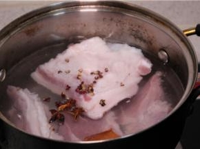 准备一锅冷水，把带皮五花肉放进锅里开火煮，水开后放少许生姜、花椒、八角煮。