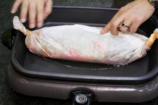 将炒好的各种调料和汤水一起倒在鱼上，用锡纸包好，卷好边缘压紧。