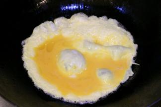 锅中倒入适量油，小火倒入蛋液，稍微凝固后搅散成块