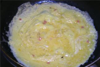 取一块黄油入锅，油化开后转中火，倒入蛋液