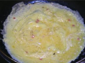 取一块黄油入锅，油化开后转中火，倒入蛋液