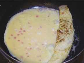 第一层蛋液凝固后卷成蛋卷，倒入第二层蛋液，依次煎成型