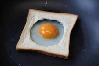 吐司放上后打入一个鸡蛋，保持蛋黄在中间