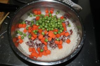 把香肠、胡萝卜丁、青豆全都放进去，加入少许的酱油和盐提味，搅拌均匀