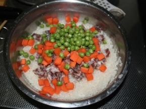 把香肠、胡萝卜丁、青豆全都放进去，加入少许的酱油和盐提味，搅拌均匀