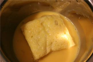 把两片吐司叠好，放入蛋液中浸透